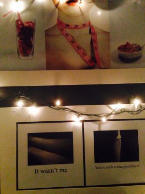 senior Michelle Booth's work displayed in a dark make shift room with fairy lights