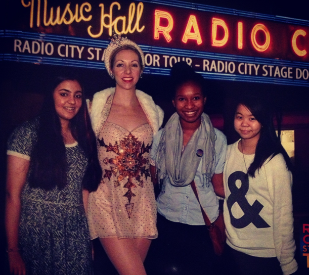Malieka Rehman, Kayla Waysome, and Patricia de Guzman stand in front of Radio City Music Hall, where they were able to meet a Rockette (middle).