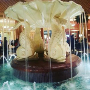 The lobby of the Dolphin Resort has a fountain with statues of fish surrounding it.
