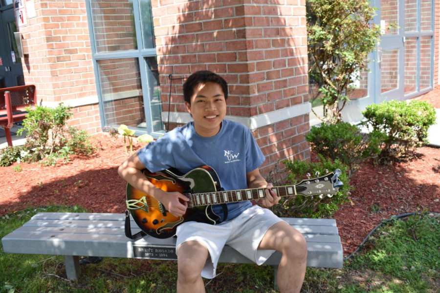Cliff poses with his guitar outside of school