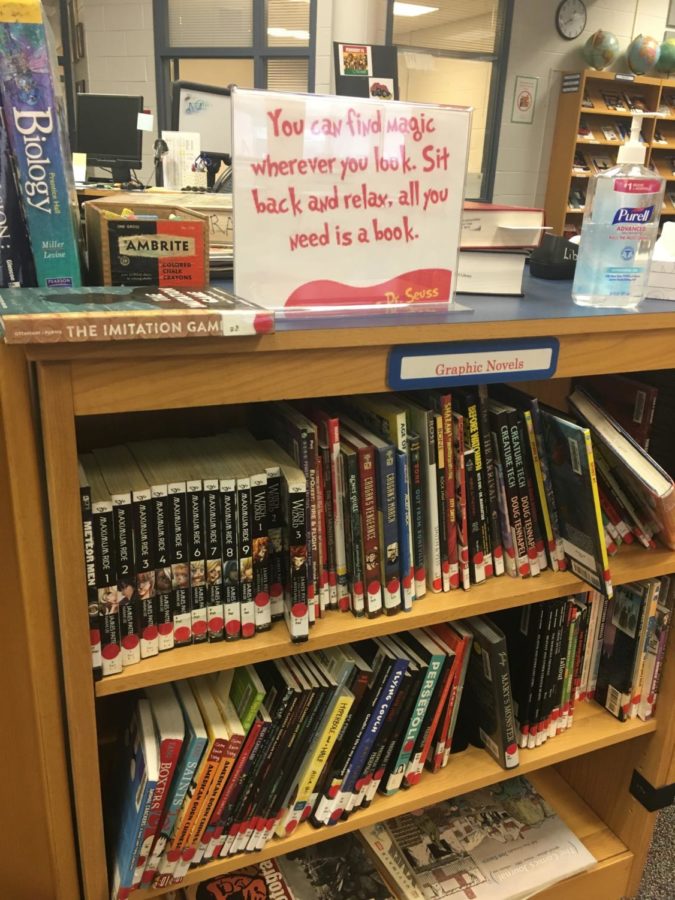 A shelf of books in the library with a motivational quote reminds students of the importance of reading.