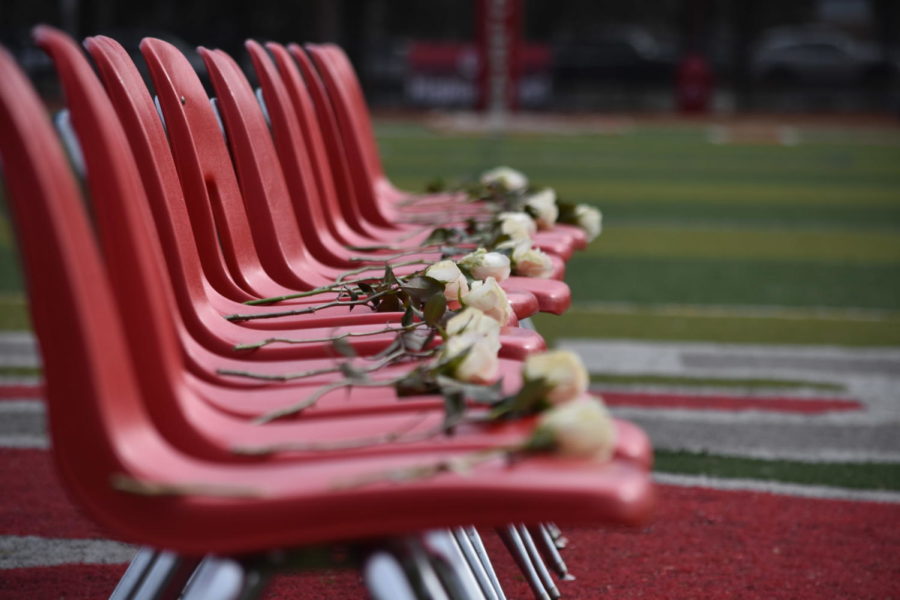 17 chairs are set on the middle of the football field to honor the lives of those lost during the Parkland shooting