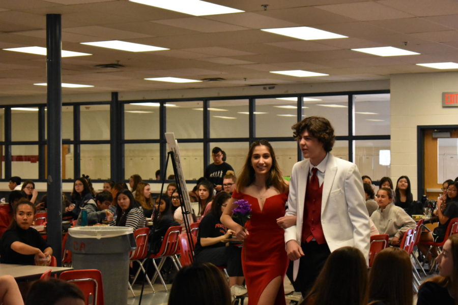 Junior Reyna Hershberg and Kemp Guas make their entrance to the runway. They are matching in red.