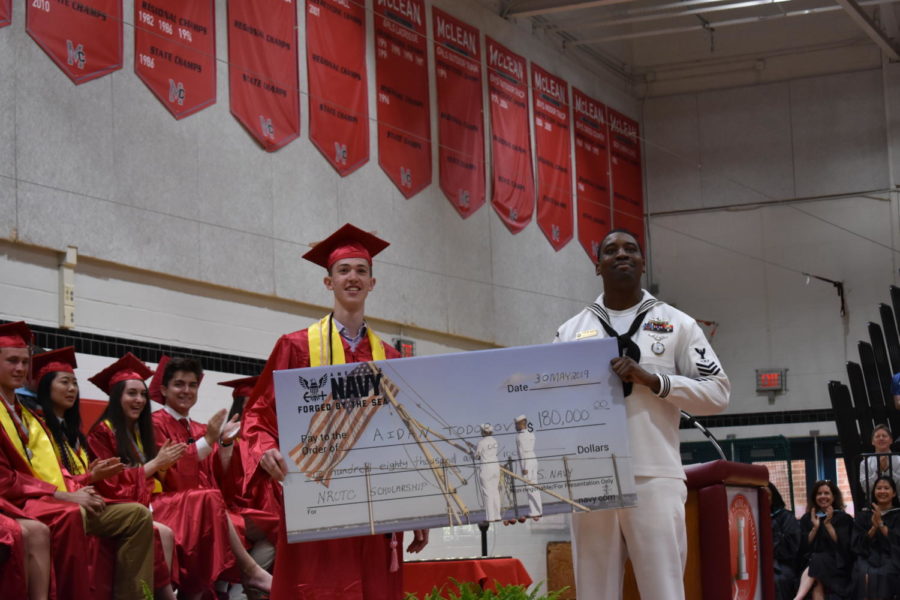 Aidan Todorov stands proud holding $180,000 scholarship for NROTC program.