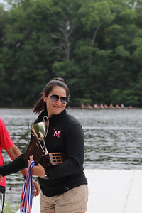 Coach Bianca Arrington holds the 2V trophy and medals