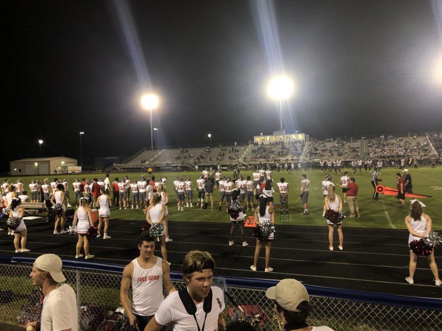 Varsity football players and cheerleaders watch from the sidelines at the first game of the season against Osbourne Park HS. This was the teams first victory since 2016.