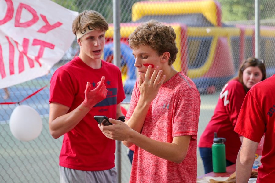 Sophomore Aaron Bremser and senior Pierce Laszlo work to get properly spirited for the tailgate. Since the game is a red out, they deck themselves up in red paint to support the Highlanders. 