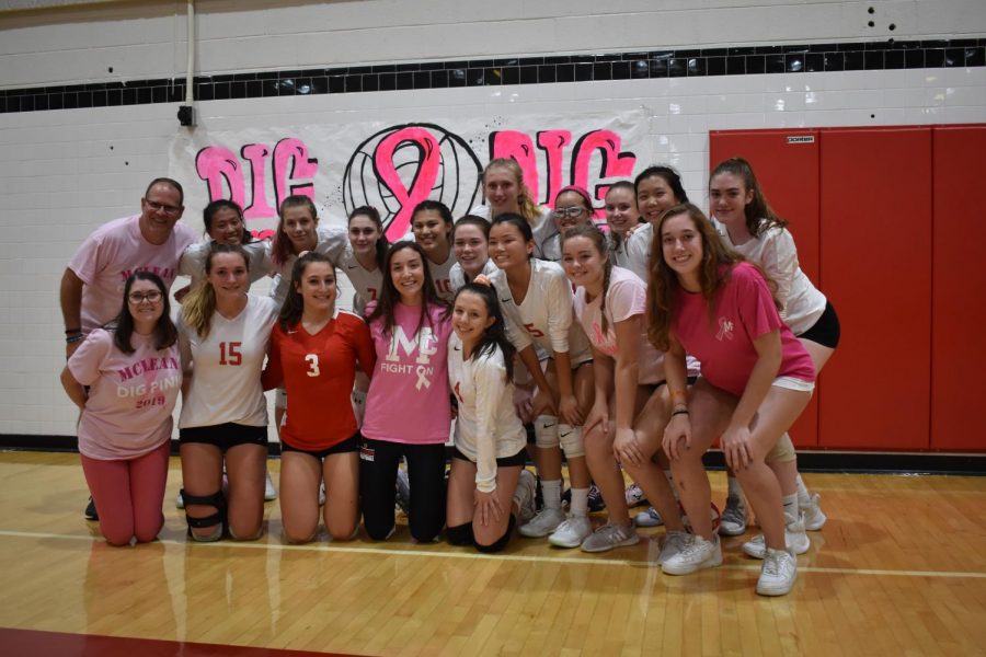 The varsity volleyball team huddle together for a photo after their win against Yorktown on Thursday. They raised over $7,000 for breast cancer awareness. (Photo by Isaac Lamoreaux) 