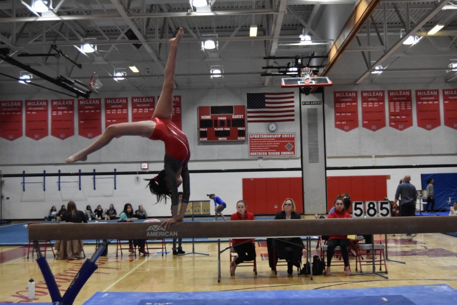 TUMBLING TARA—Senior team captain Tara Stewart competes on the balance beam at the home meet on Dec. 2. She has been practicing gymnastics for 14 years.