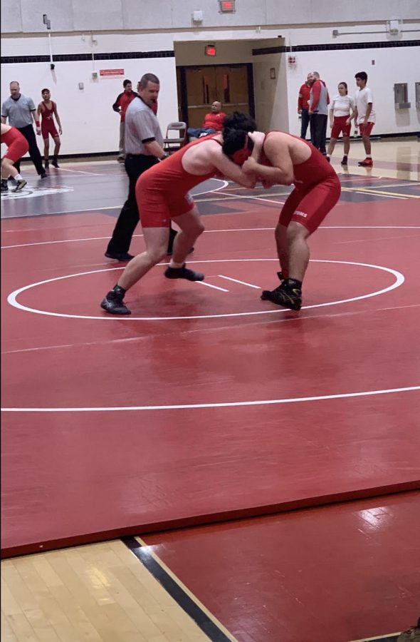 Charlie Poole in the 220 pound weight class , depicted on the left, taking on his opponent from Annandale.