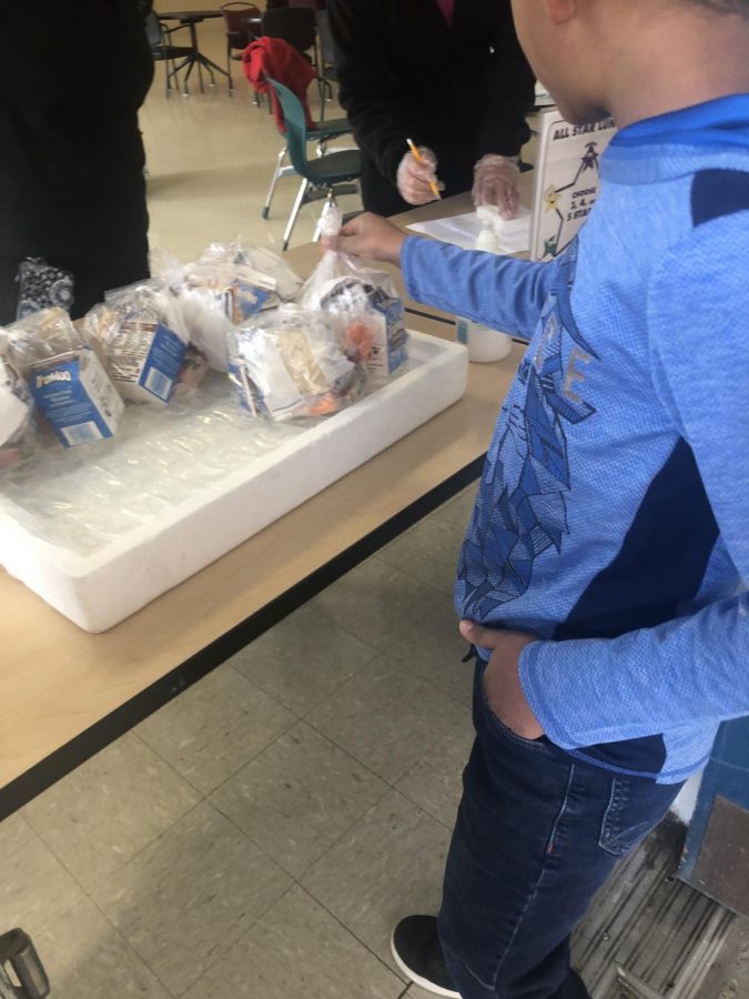A student picks up a grab and go lunch and the Graham Road Community Center. Offering free lunches at various locations is one of the ways FCPS tries to help families deal with the implications of the spread of the coronavirus.