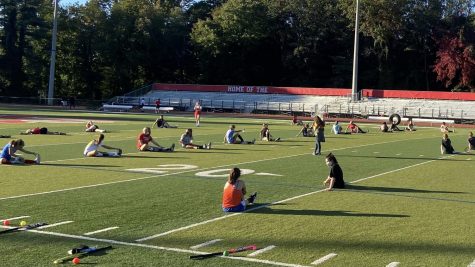 Field hockey athletes stretch during the Oct. 8 green day. The players remained socially distant in order to have a safe practice for everyone who attended.