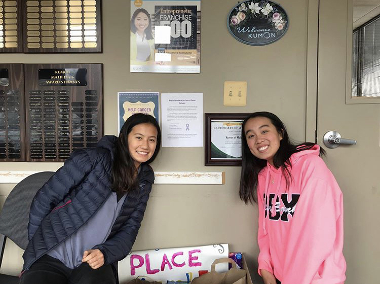 Posing For Donos - Founder Olivia Zhang (right) and club officer Thais Rolly display their Kumon donation event gatherings. These donations consisting of toys, books, and games were shipped to the Cincinnati Children Hospital. (Photo courtesy of Xiaowei Zheng)
