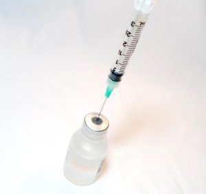 A vaccine is being prepped for injection. Pfizer claims that 15-20 million people will have access to their COVID-19 vaccine by the end of 2020. (Photo obtained via Creative Commons)