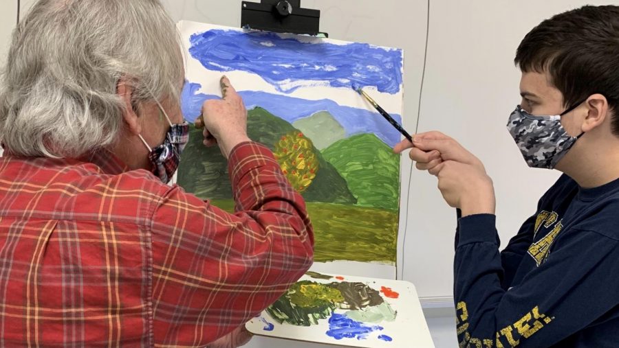 CREATING BEAUTY - Teacher John DeMers works with junior Alex Pisocky on a painting during Highlander Time. DeMers often teaches students techniques that he has learned from his art instructors.