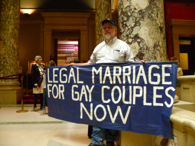 LEGAL BATTLE — A protestor stands outside the Minnesota Senate chamber, urging for the legalization of gay marriage. Gay marriage is major example of when legislators have taken an excessively long time to grant basic rights because of different political ideologies.
