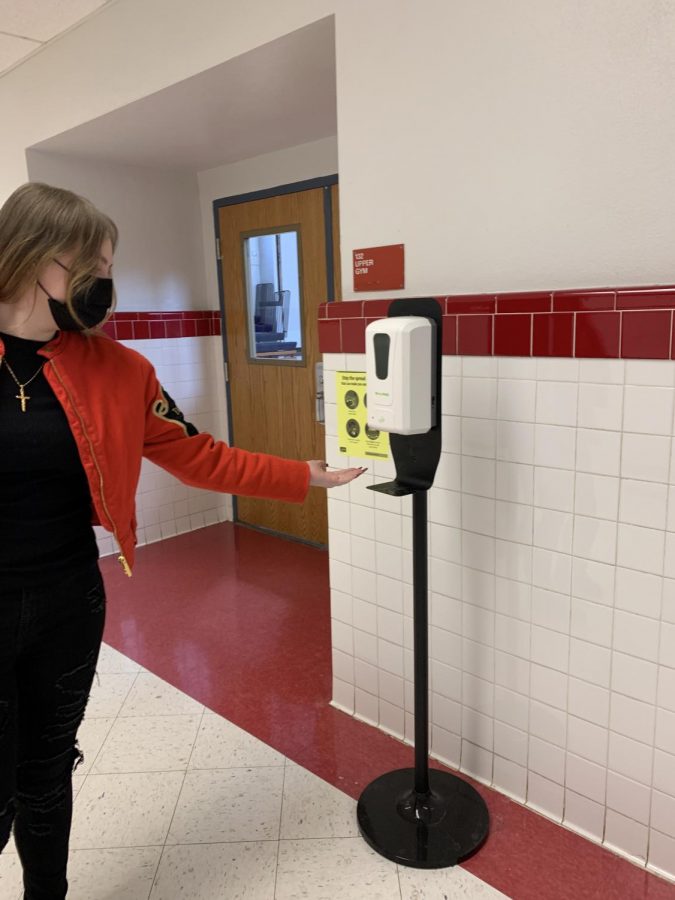 Here, a student utilizes one of the many sanitizing stations spread throughout the school. This helps students kill germs.