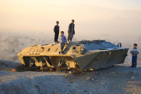 Desert Deployment — Three Afghan children stand atop a military vehicle in Kabul. The decade-long war against terror has affected the lives of many innocent civilians. (Photo obtained via Creative Commons) 