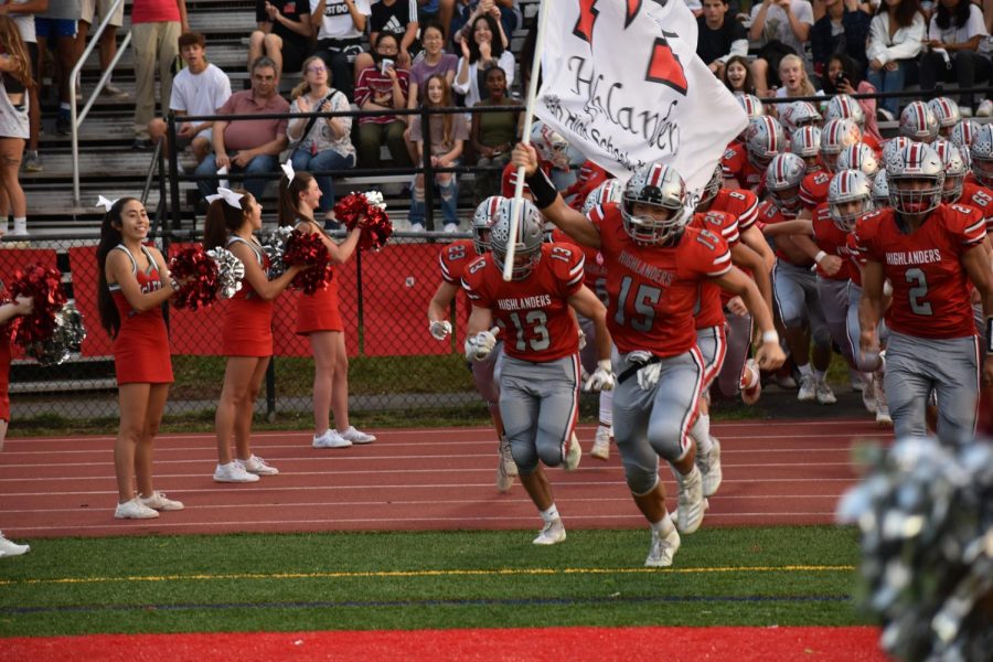 Jihao Liu runs onto the field wielding the McLean flag. Liu was selected to the Second Team for his play as a defensive end.