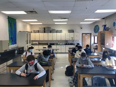 Students sit in a classroom half empty.  Many classes had empty seats due to an increase in COVID-19 contact tracing and cases, as well as the upcoming winter break and students opting to stay home.