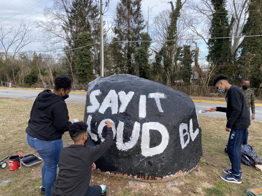 Rocking the black — Black Student Union members paint the rock to commemorate for Black History Month. “Painting the rock meant a lot to me because we were able to spread awareness of the different races at McLean,” junior Zachary Mitchell said.