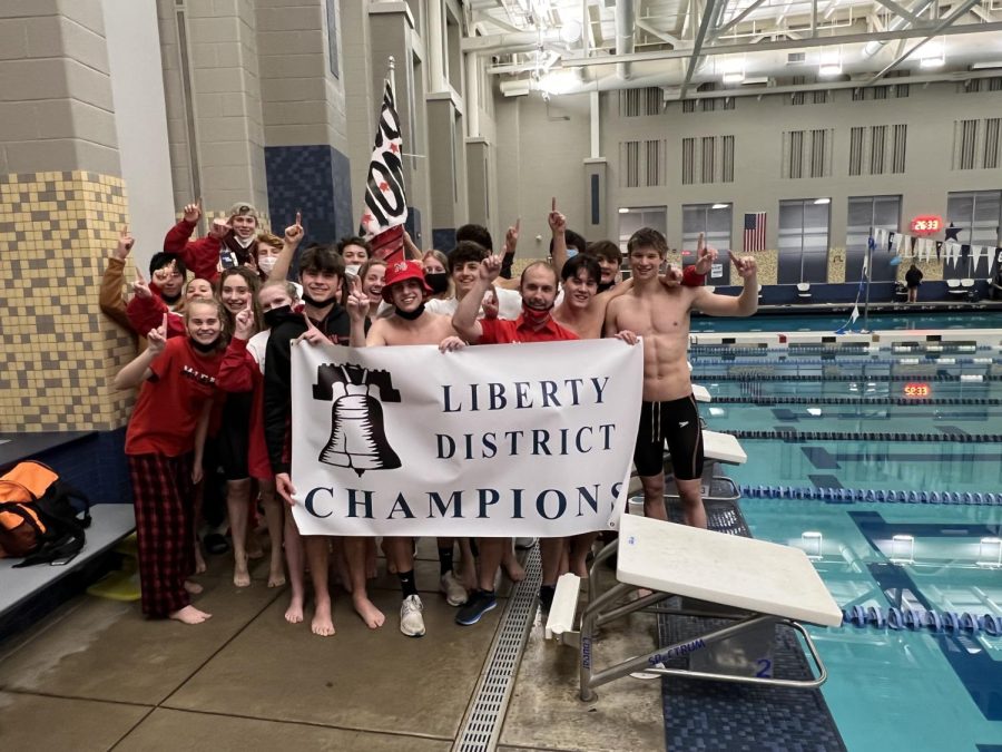 McLean Swim & Dive poses with the District Champions banner