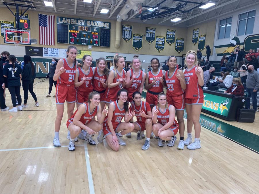 Junior Kara Bremser (rightmost player on the front row) poses with the girls basketball team after defeating the rival Langley Saxons on Feb. 16.