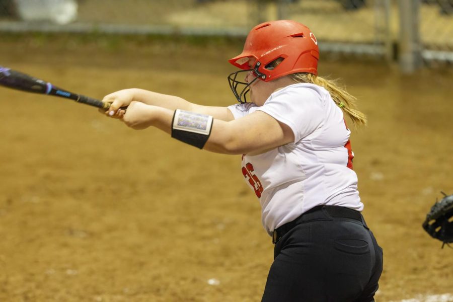 Senior Lily Brumbaugh swings and hits the ball at home base.