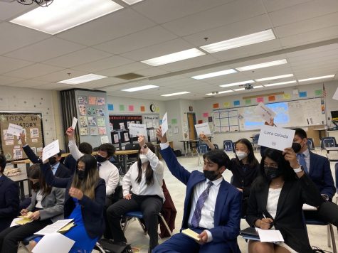 Students raise their placards to vote on a measure. “Participants are really, really passionate about everything theyre doing,” Model United Nations club sponsor Amanda Williams said. “As a teacher, its a big moment of pride to see that come out at conferences.”