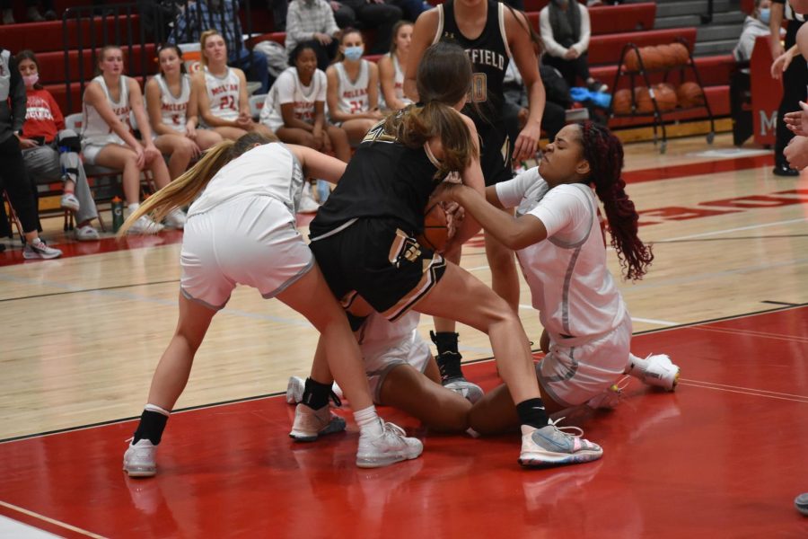 McLean sophomore Ava Stewart wrestles for control of the basketball. The physical scrum was symbolic of the Highlanders mental toughness.