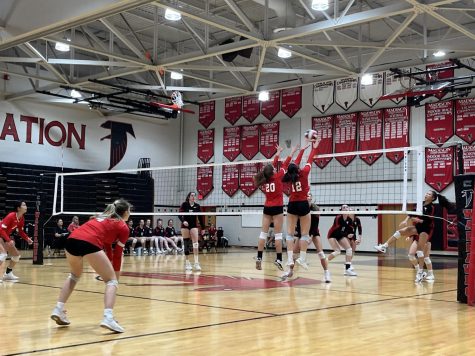 Sophomore Alexa Sribar (number 20), and senior Jessica Lin (number 12) deliver a clean block, securing a point for the Highlanders.