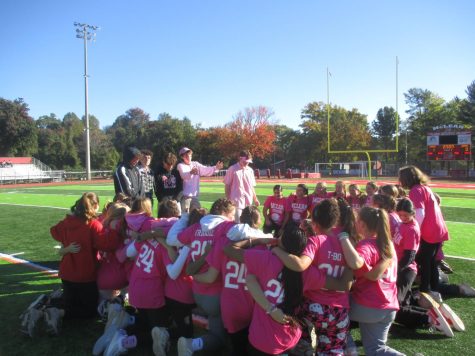 The junior girls huddle in a circle and listen to a pre-game pep talk led by their junior boy coaches. 