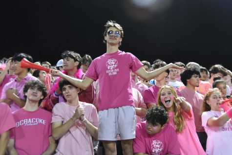 Senior Charlie Jackson leads the Highlander student section, dressed appropriately for the Pink Out theme.