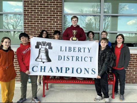 Quiz Bowl team holding up the Liberty District Champion banner.
