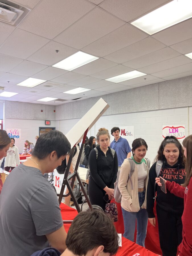 Students discuss their product with potential buyers during the Market Day.