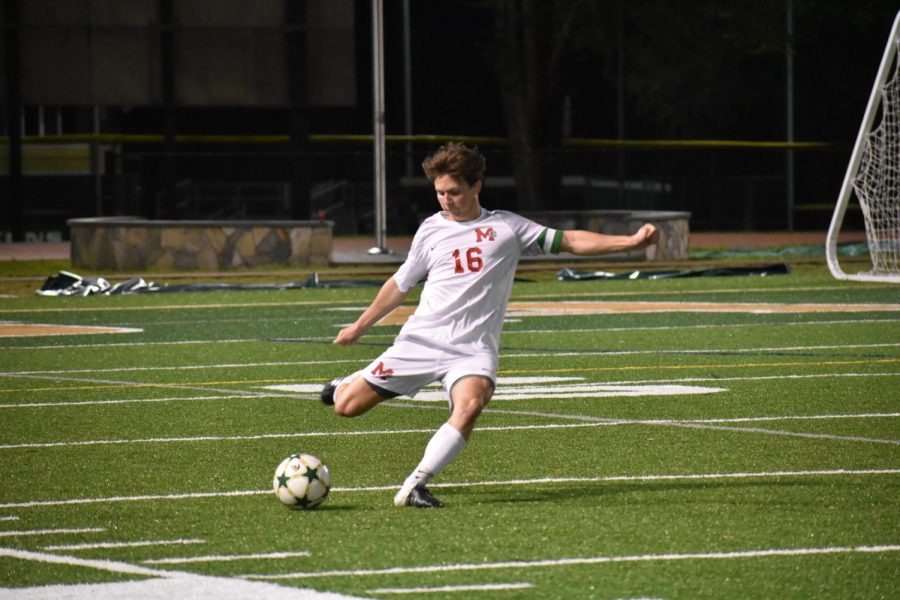Senior Jeremy Jeannot takes control of the ball, setting up for a powerful kick down the field.