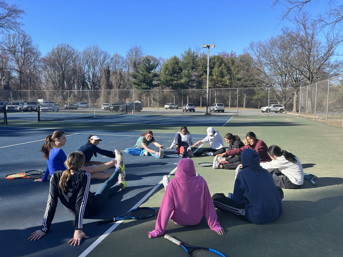 The girls tennis team cools down in a stretch circle after practice. 