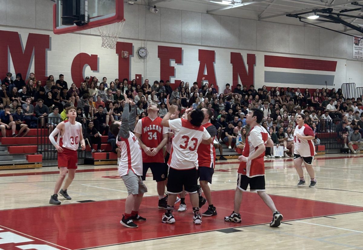 As the student body spectates, the red team makes a shot, the ball hovering over the net. The red team ultimately secured a 31-29 win over the silver team.