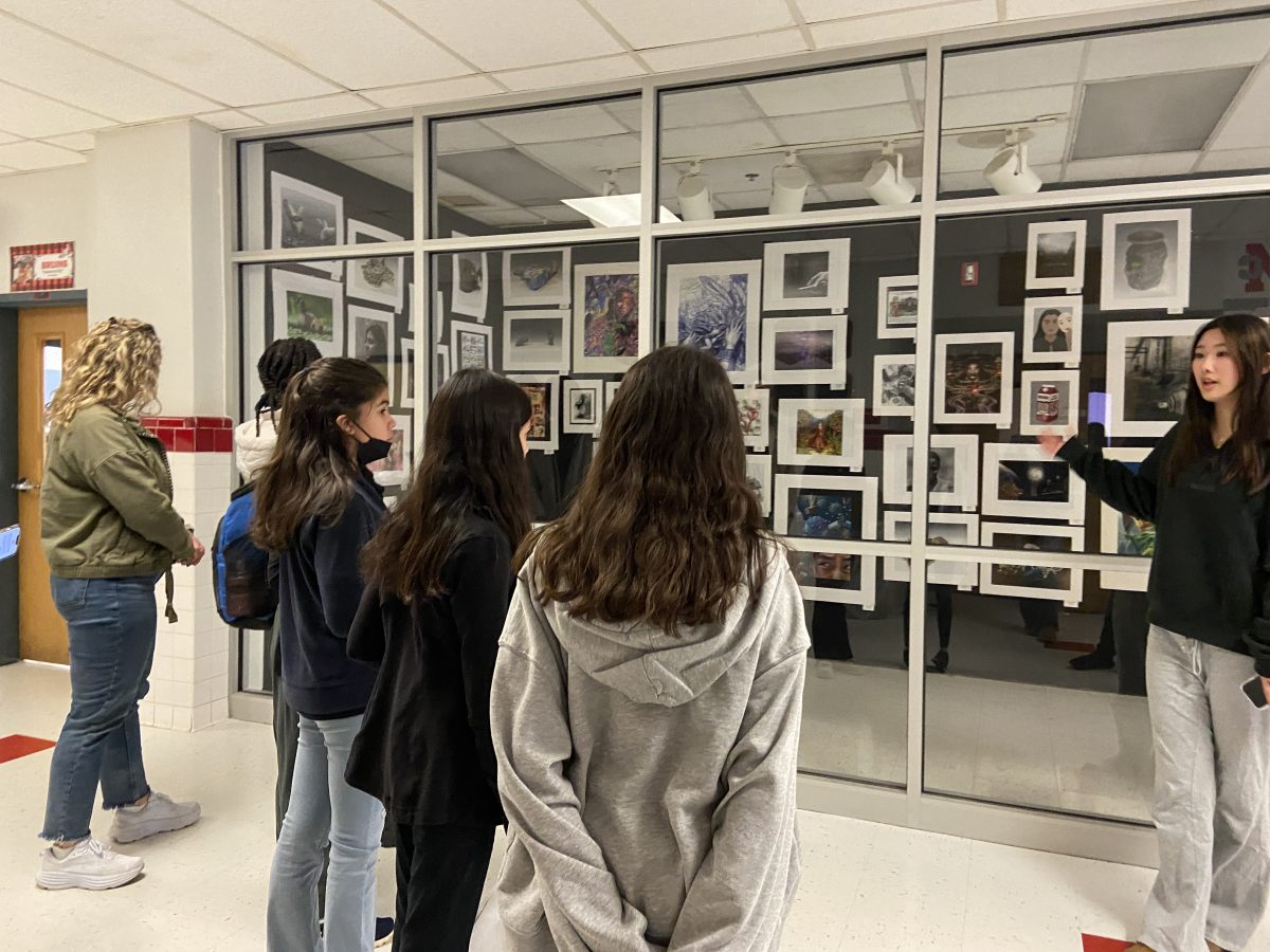 Junior and SEALs member Emily Ma guides students around the school and explains the art exhibitions.