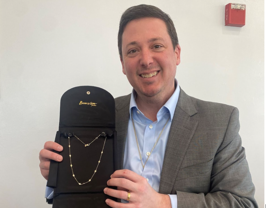 Vice president of Boone and Sons Erik Boone poses with the diamond necklace donated to the PTSA auction. The necklace, with a $2,000 value, is one of the auctions most expensive prizes.