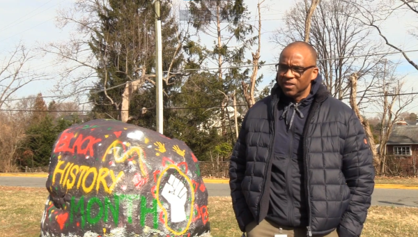 Safety and Security Specialist Bart Bailey discusses the significance of painting the school rock for Black History Month in a video shot by McLeans News Channel, WHMS News. Quietkid4 screenshotted a frame of the video and posted it to Reddit, claiming the rock was his schools.