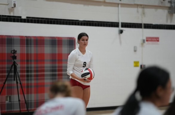 Senior volleyball player Adrienne Long prepares to serve at a high school game. She will continue her volleyball career next year at Union College.