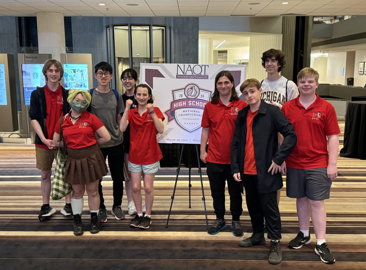 The quiz bowl team poses by the NAQT National Championships sign at the tournament held in Atlanta, Georgia. With a top-50 finish, it was a strong end to the season. 