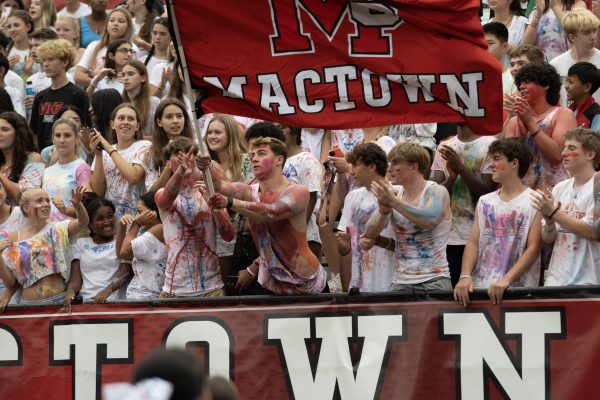 Senior Aaron Chandler waves the MACTOWN flag in the McLean student section following a touchdown.