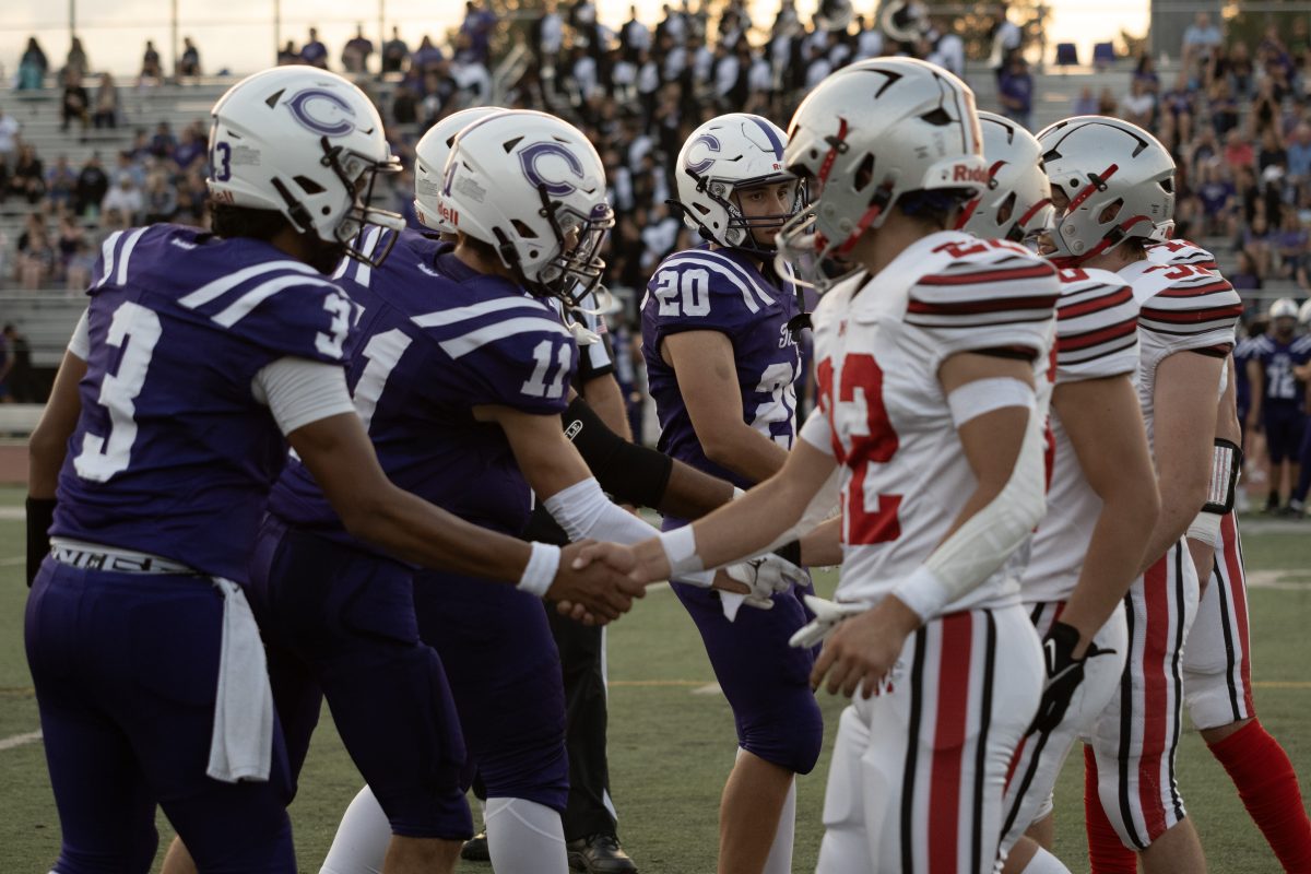 The Highlanders' and Chargers' captains shake hands as they meet for the coin toss.