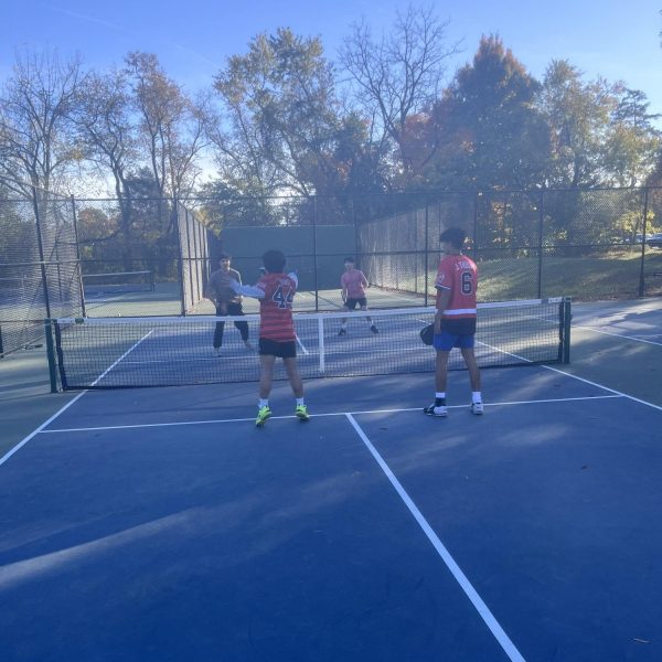 Senior Vernon Ngo hustles to the ball to smack it into the opponent's zone. The team performed well, winning the match.