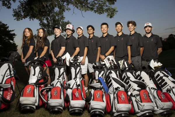 The Highlander golf team poses for a team picture behind their bags. The team had a successful season, with several big wins.