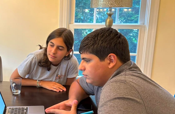 Junior Maria Ayvazyan and her cousin Eduard Yeremyan take a look at the money they have earned through fundraising. With these funds, they acquire resources for war-torn Armenian families.