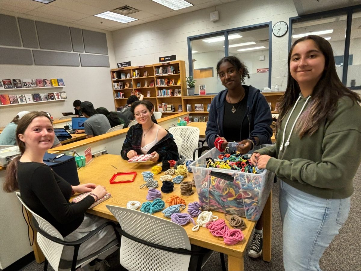 McLean students creating potholders in the library. They picked out their colors and added their names to the library display board after completing one.