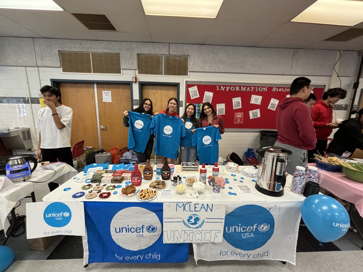 UNICEF club leaders proudly displayed their shirts as they finished setting up their stand at last year's Holiday Bazaar. The club will host the same event this year to support children in need.